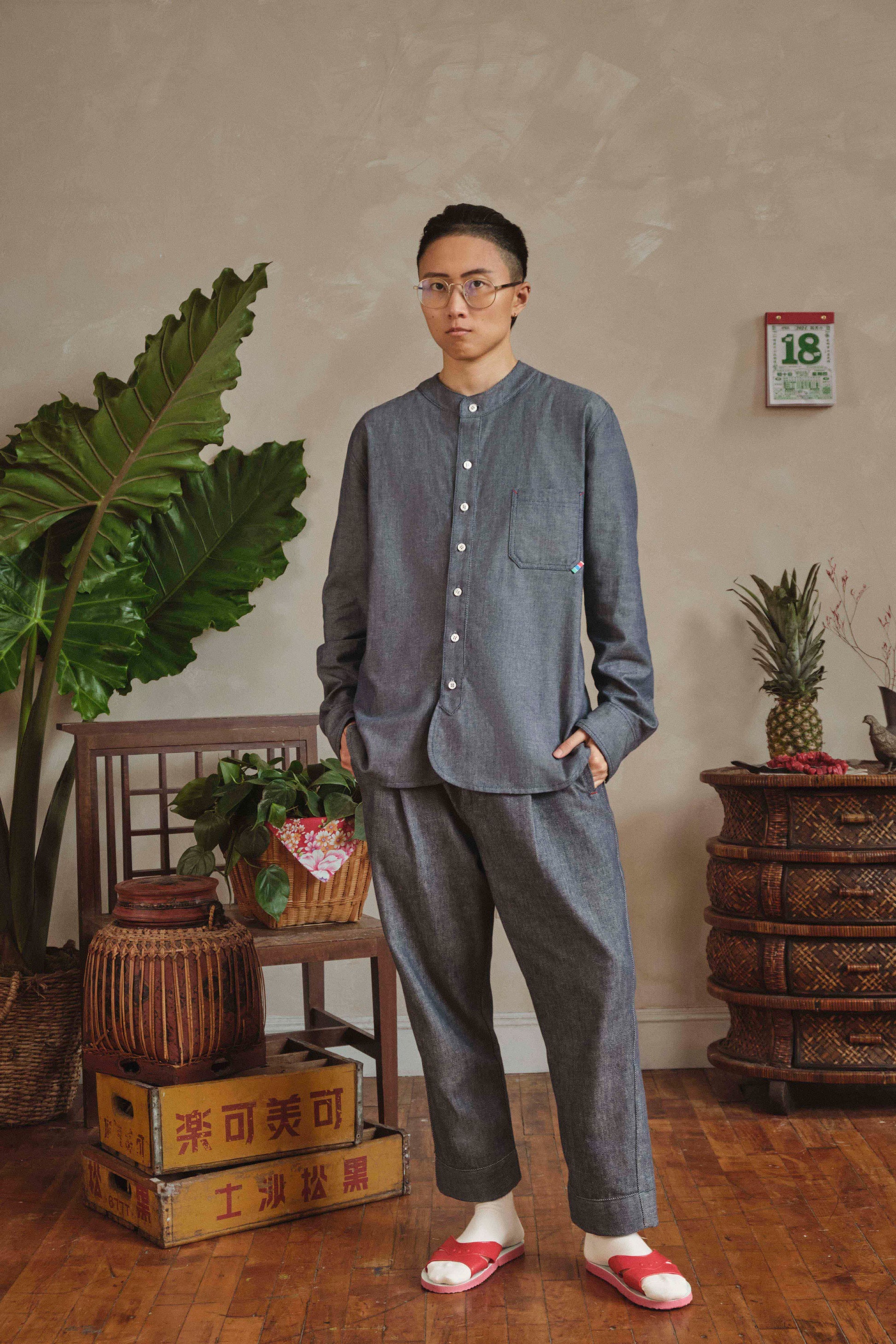 Model wearing denim band collar shirt, front view
